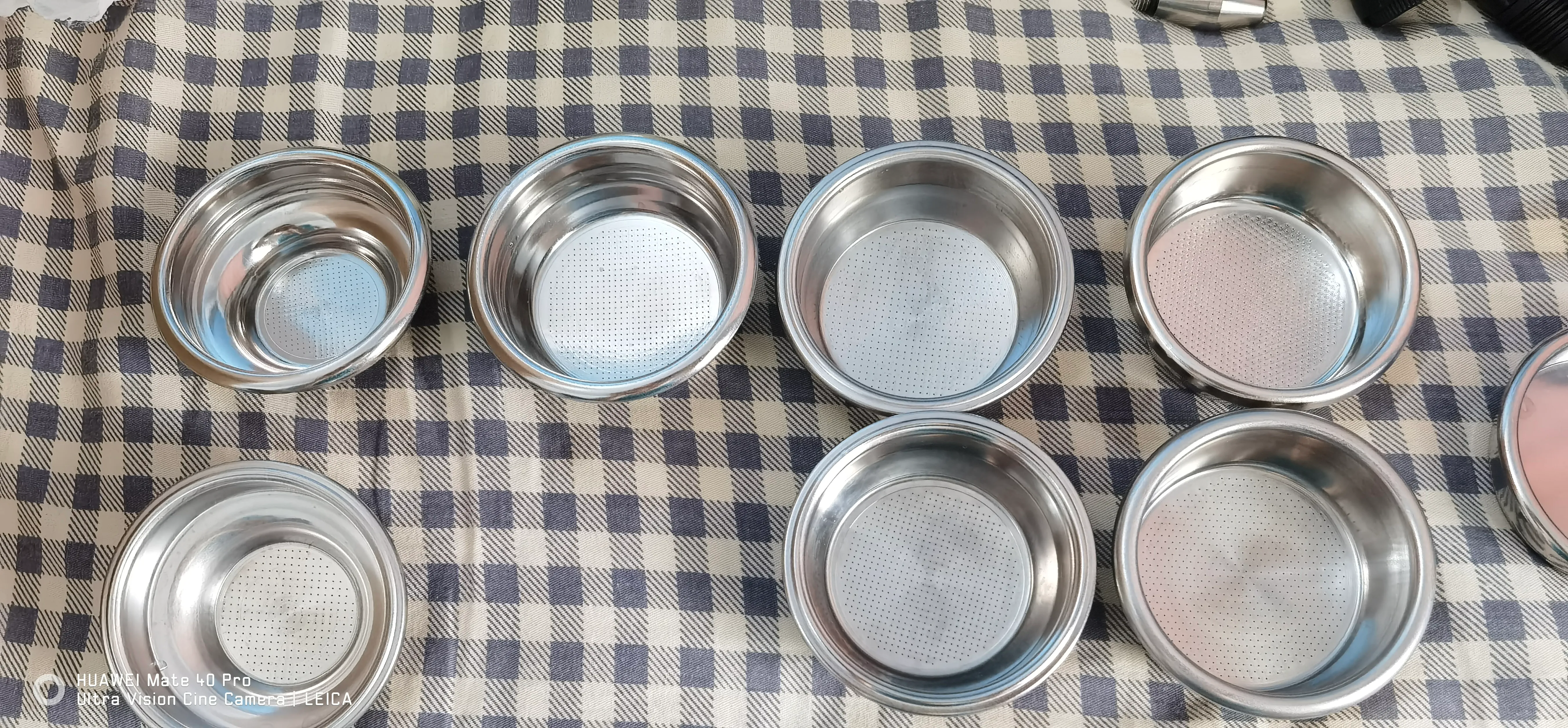 不同容量和孔型的意式咖啡粉碗整齐排列在桌面上